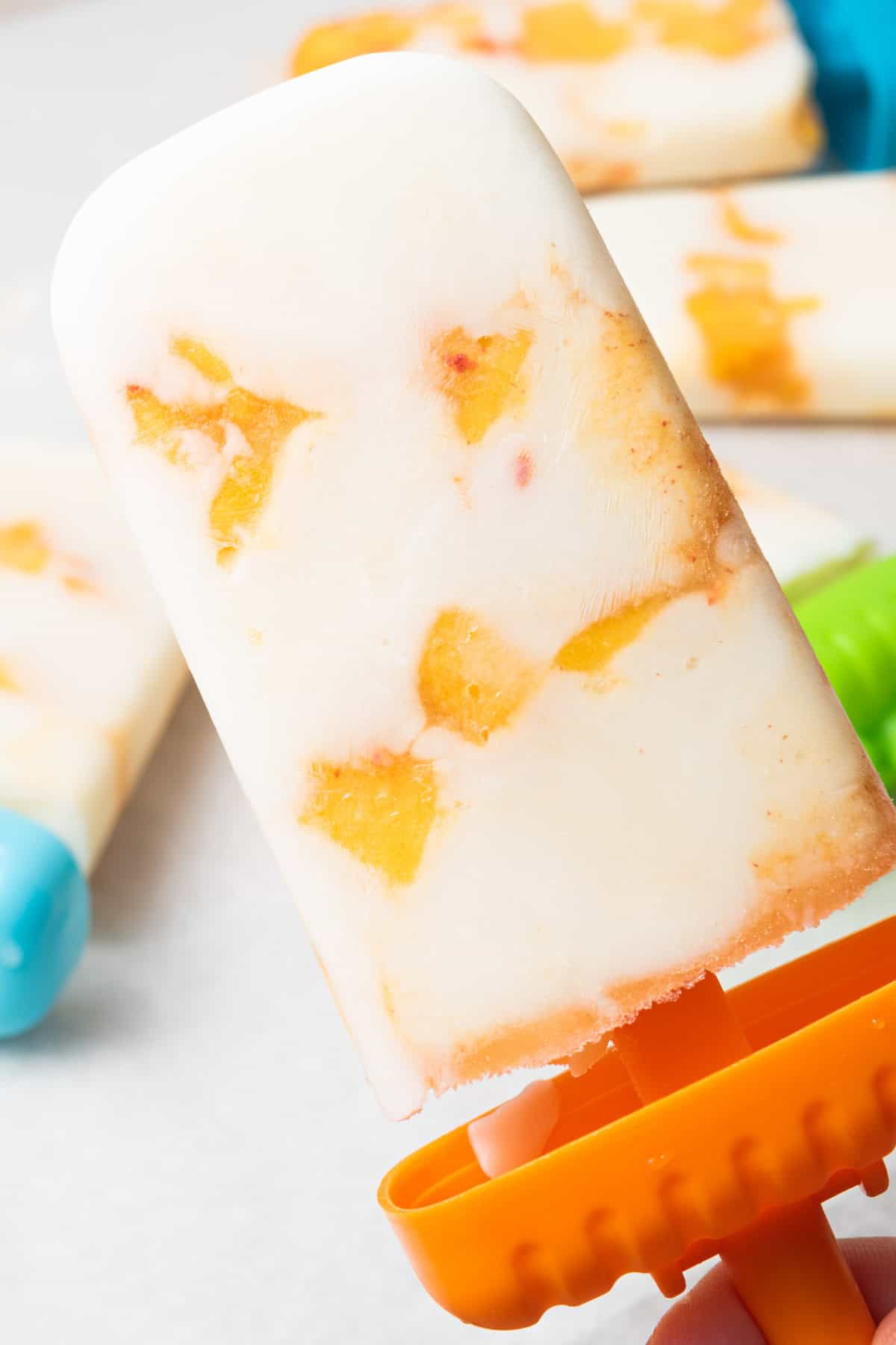 A homemade peaches and cream popsicle with vanilla yogurt and honey.
