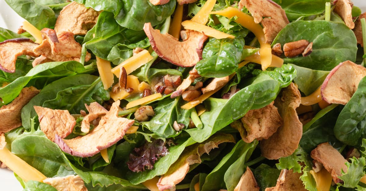 Green salad with cheddar, pecans, and dried apples.