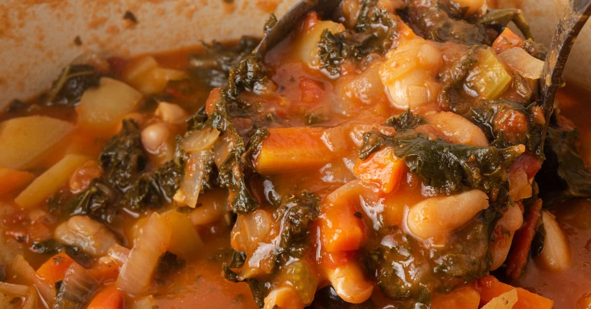 Ladling fall minestrone soup from a Dutch oven.