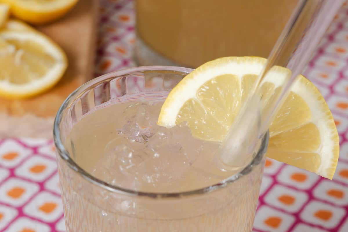 A glass of green iced tea with a lemon wedge.