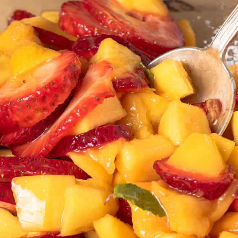 A bowl of strawberry mango fruit salad.