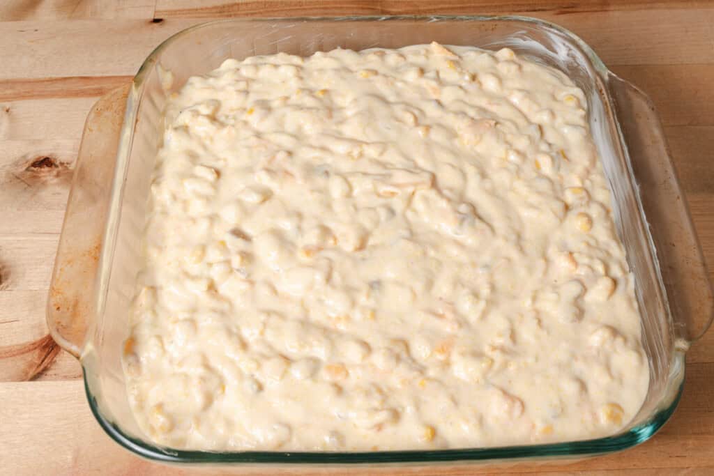 Corn casserole batter spread in a casserole dish.