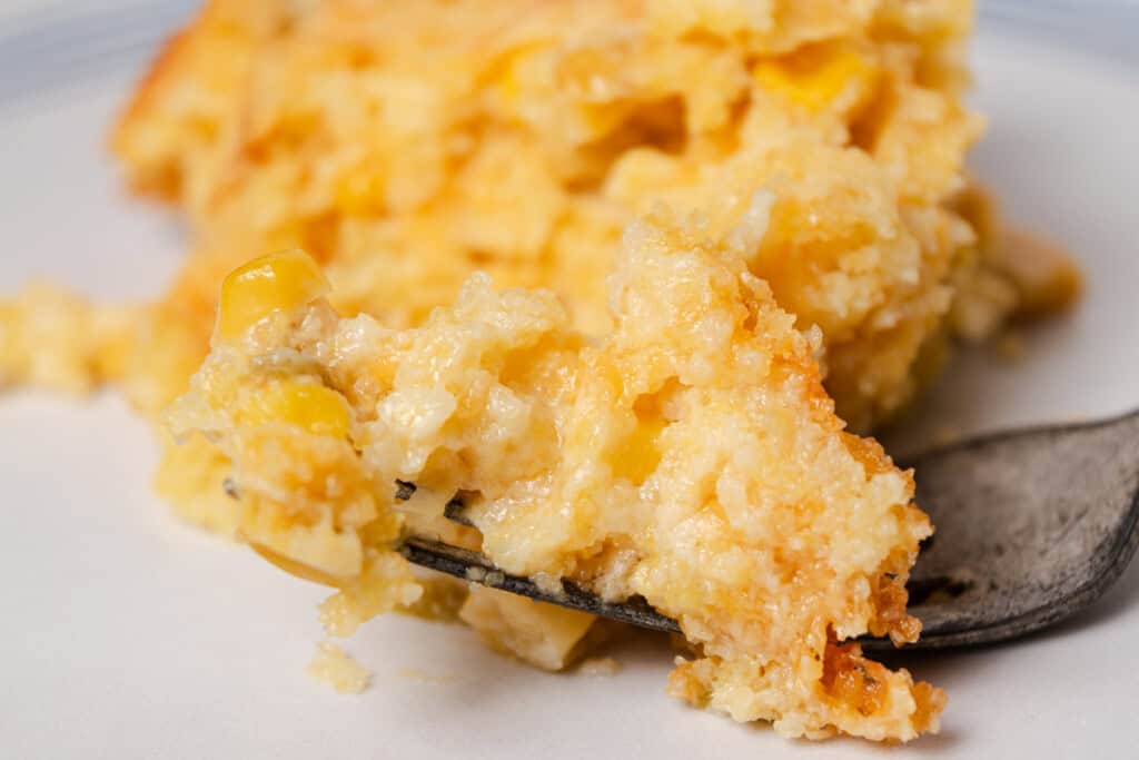A bite of cornbread casserole on a fork.