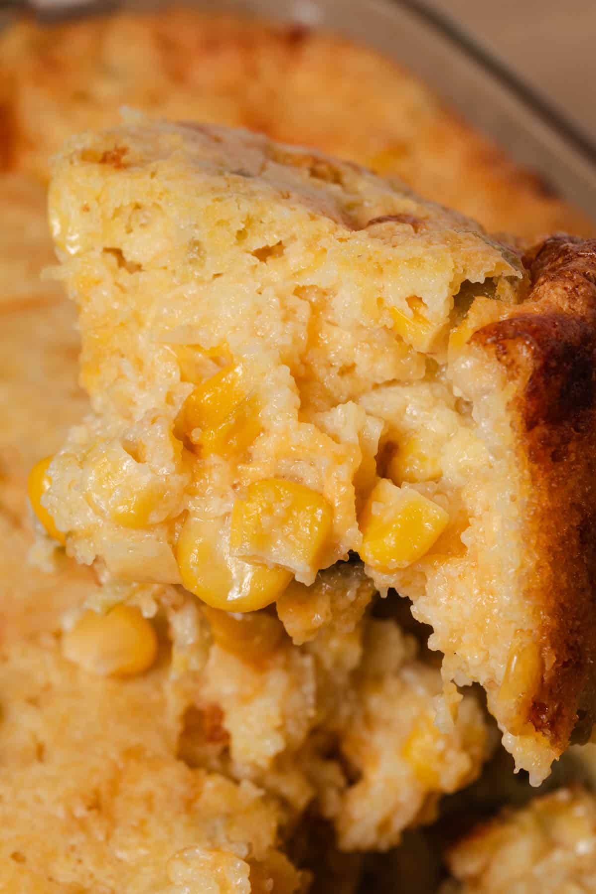 Scooping a serving of cornbread casserole from the dish.