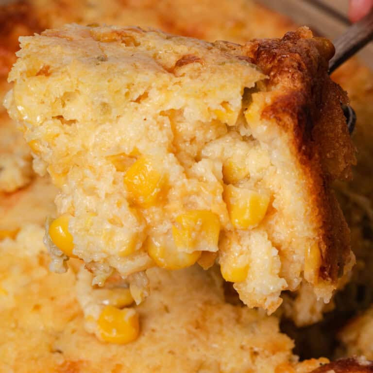 Spooning a serving of cornbread casserole from the dish.