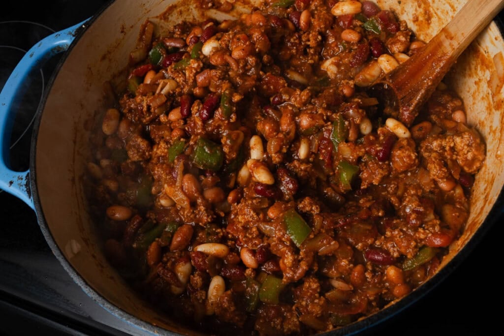 Adding the beans to pumpkin chili.