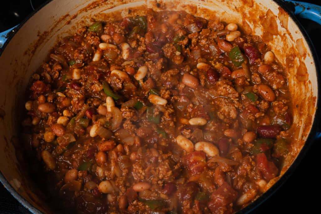 A pot of homemade pumpkin, turkey, and bean chili before simmering.