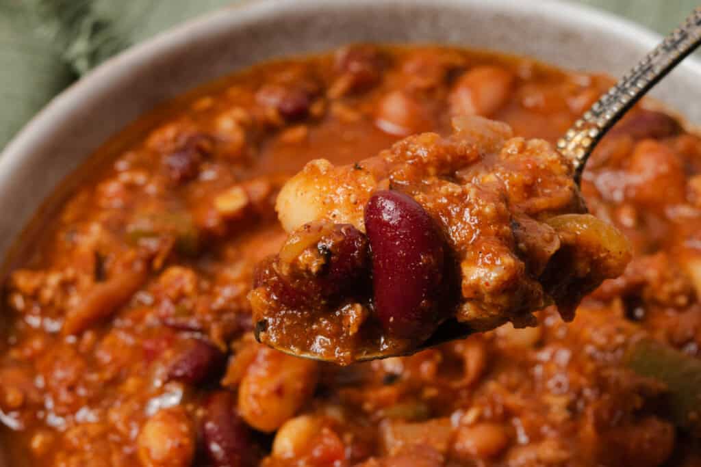 A spoonful of homemade pumpkin, turkey, and bean chili.