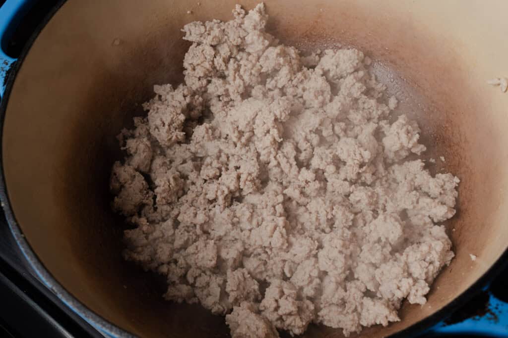 Stirring ground turkey in a dutch oven.