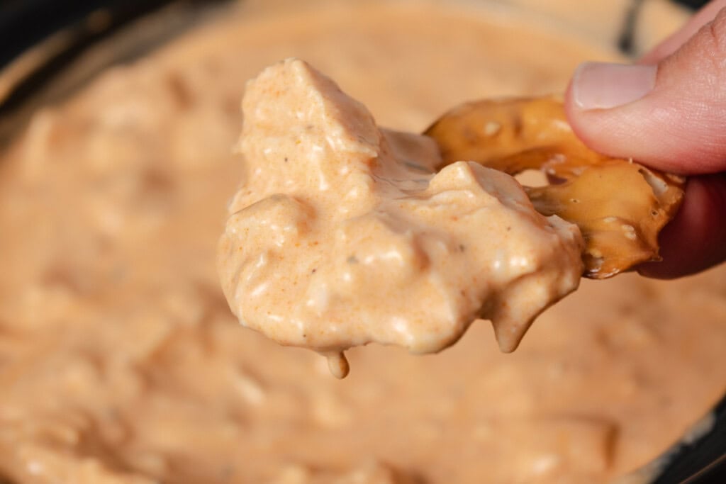 A pretzel chip dipped in slow cooker buffalo chicken hot wing dip.