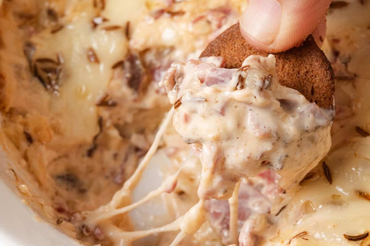Scooping up homemade hot baked reuben dip on a rye chip.