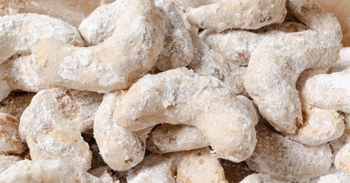 Pecan crescent cookies rolled in powdered sugar.