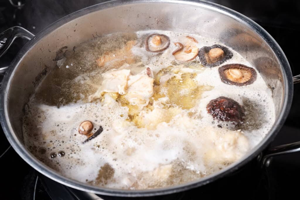 Homemade chicken stock simmering in a stockpot.