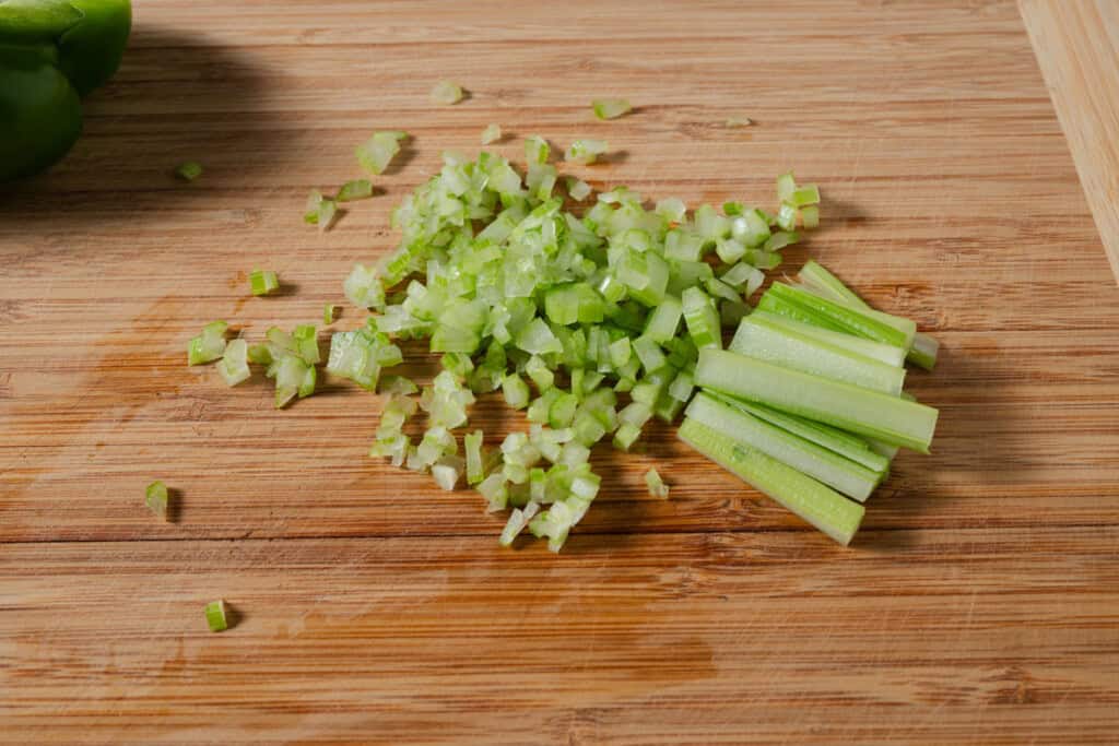 Finely diced celery on a cutting board.