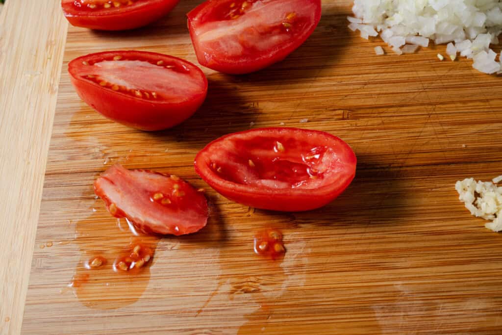 Cutting the seeds out of roma tomatoes.