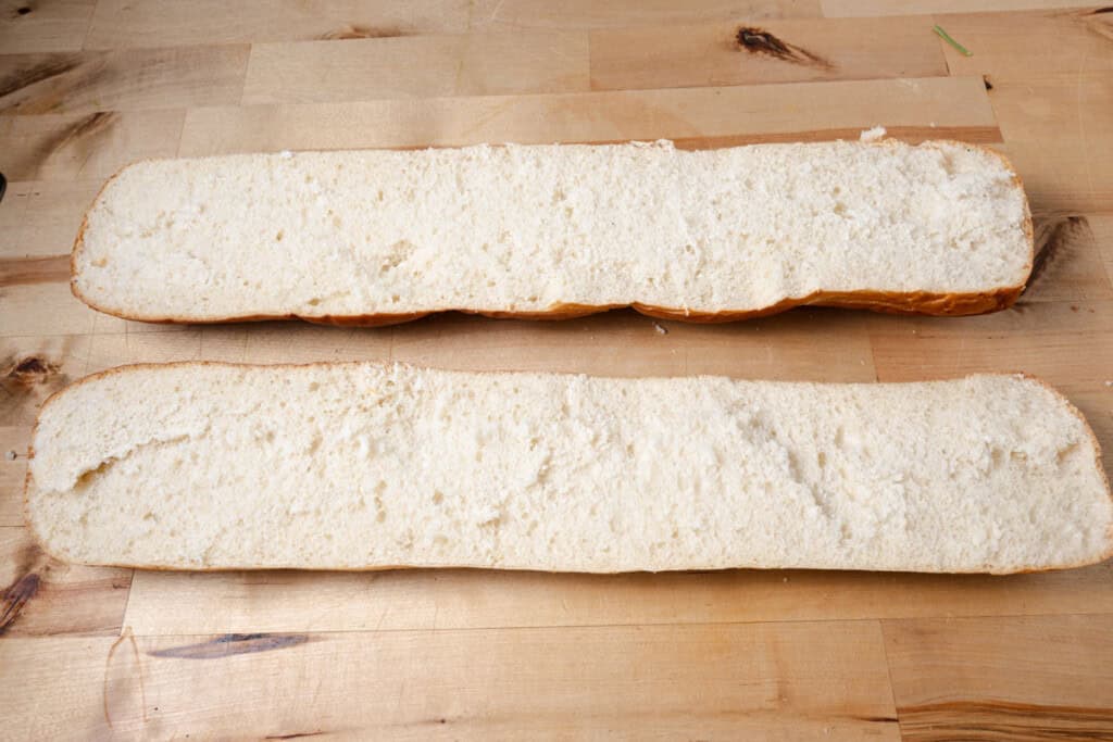 A loaf of French bread, sliced in half lengthwise.