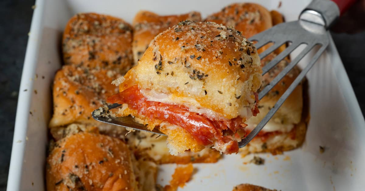 Serving a pepperoni pizza slider with a spatula.