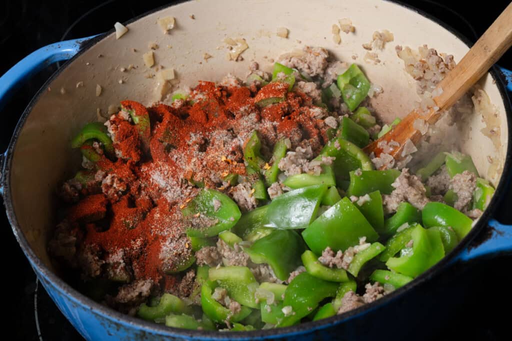 Adding spices to stuffed pepper soup.