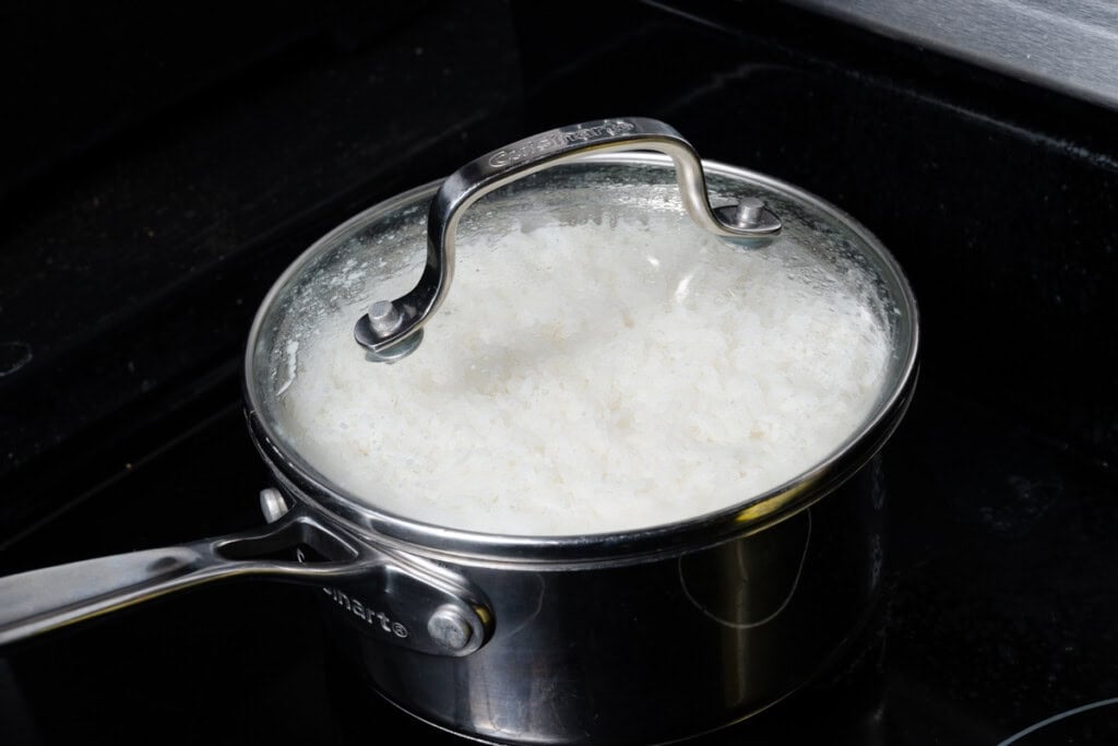 White rice cooking on the stovetop.