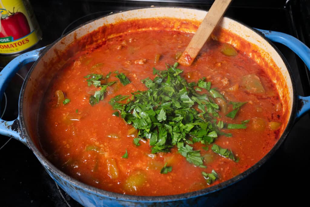 Adding parsley to stuffed pepper soup.