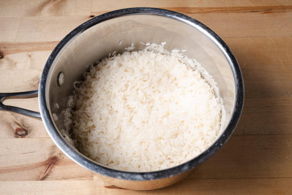 Rinsed white rice in a pot.