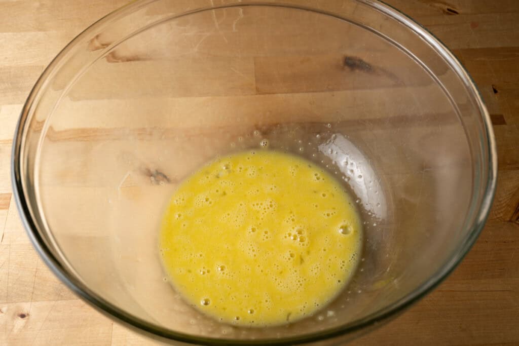 Lightly beaten eggs in a mixing bowl.