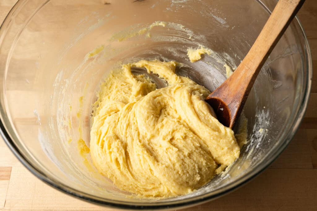 A bowl with cake mix with butter and egg for chess bar crust.