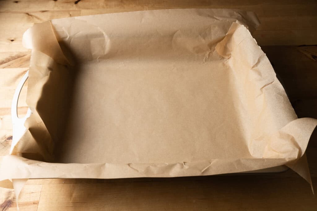 A cake pan lined with parchment paper.