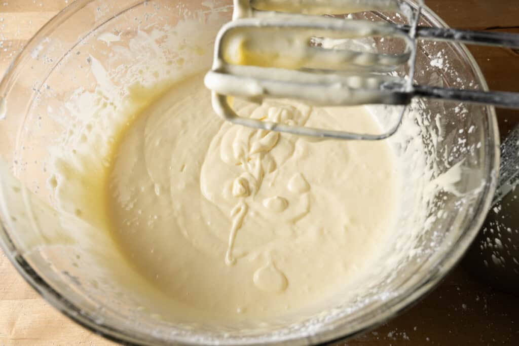 Cream cheese, eggs, and vanilla mixed in a bowl.
