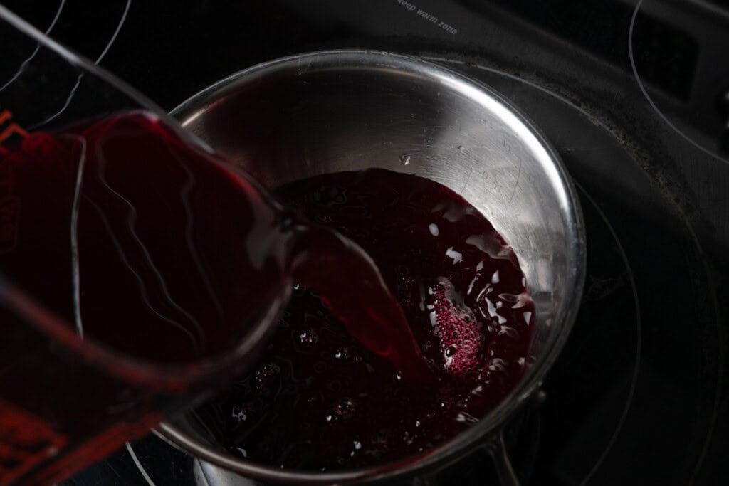Pouring pomegranate juice into a pot.