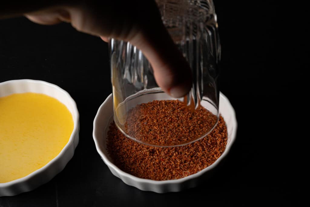 Dipping a cocktail glass rim into tajin.